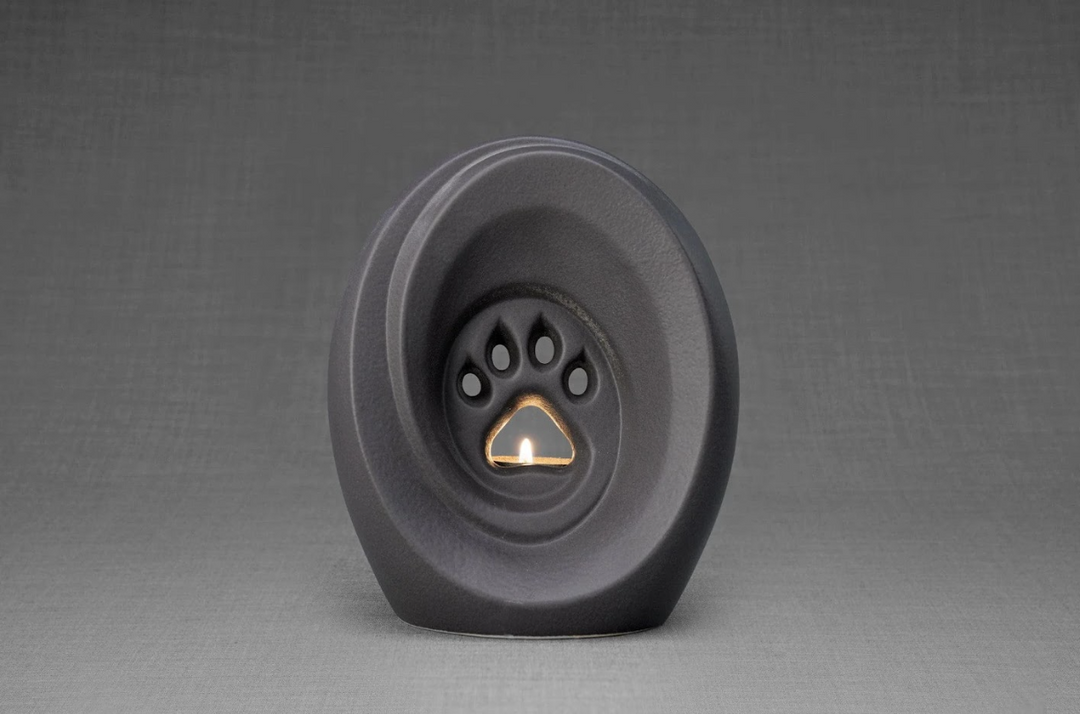 Matte gray Paw Ceramic Urn for pets with a built-in candle holder and paw print interior