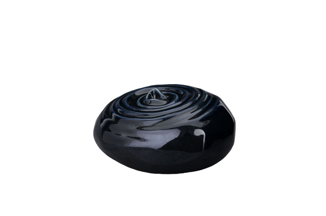 Resonance Ceramic Urn in deep navy glaze with concentric spiral design, bottom-filled.