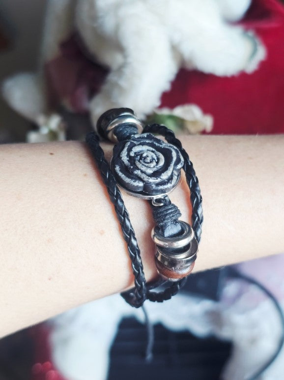 Black double wrap leather bracelet with a silver rose centerpiece and metal side beads.