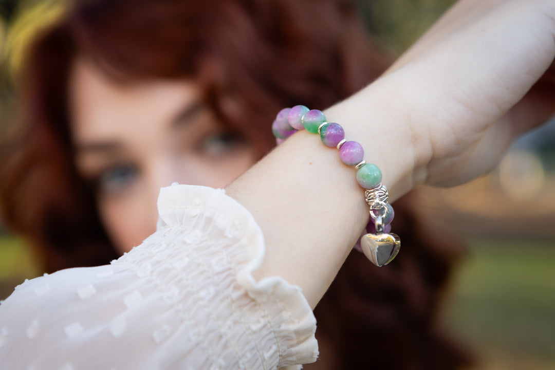 Pastel selenite keepsake urn heart bracelet on the wrist with a silver heart charm