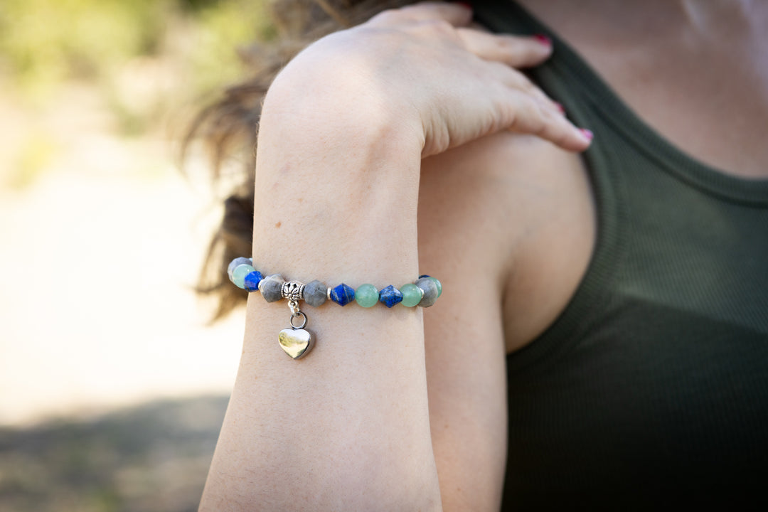Lapis aventurine and labradorite beaded keepsake urn heart bracelet on the wrist with a silver heart charm