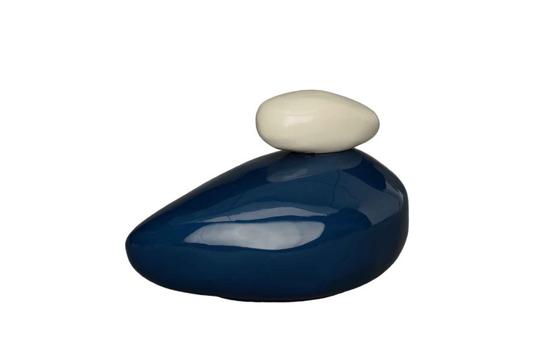 Cream lid stone resting on a navy Stone Ceramic Urn