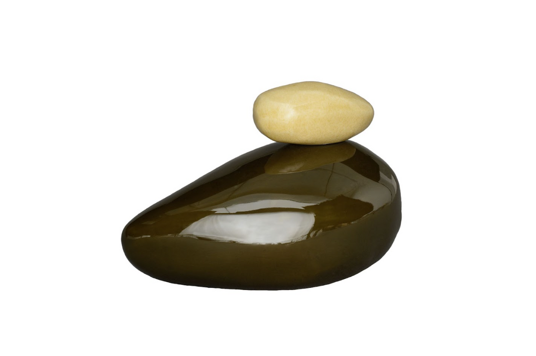 Glossy dark olive brown stone with a pale beige stone perched on top