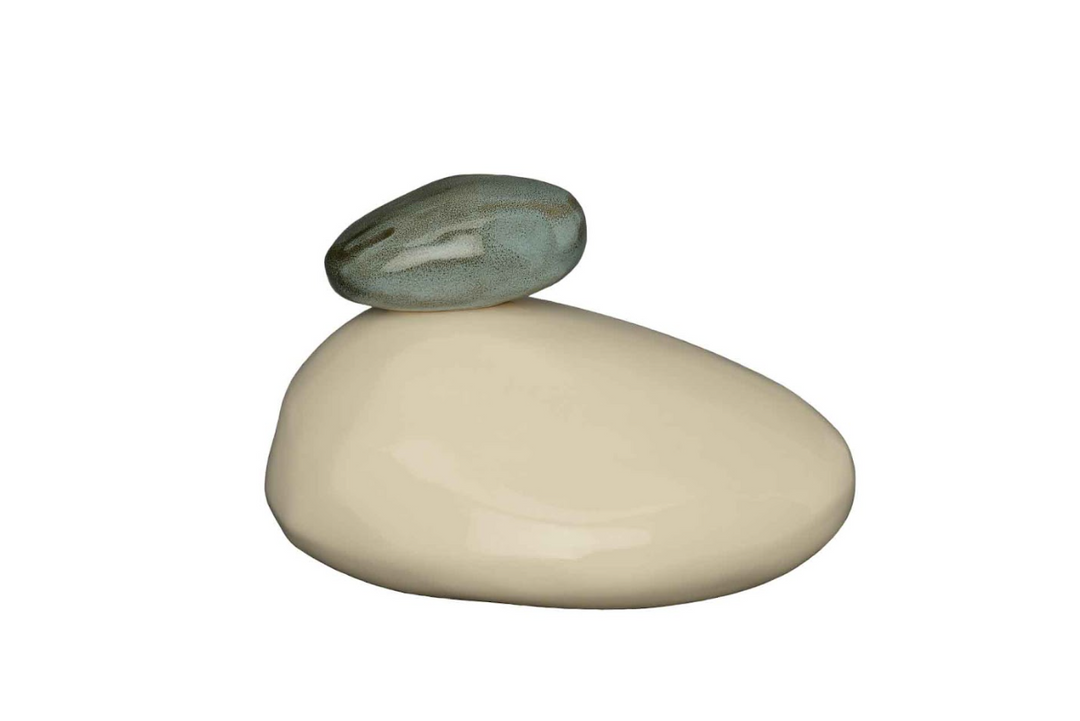 Beige rounded stone base balanced by a smaller gray green stone on top