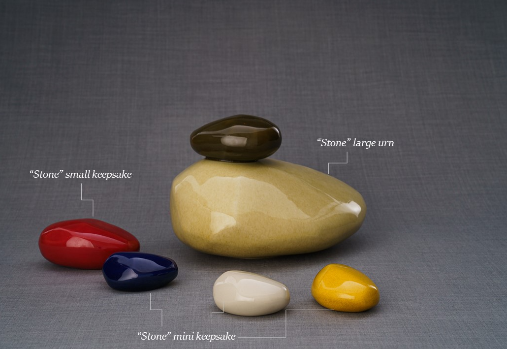 Stone Ceramic Urn with a dark lid sits among red blue cream and yellow keepsake stones