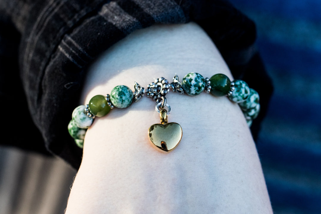 Navy blue and white bead keepsake urn heart bracelet with a gold heart charm worn on the wrist
