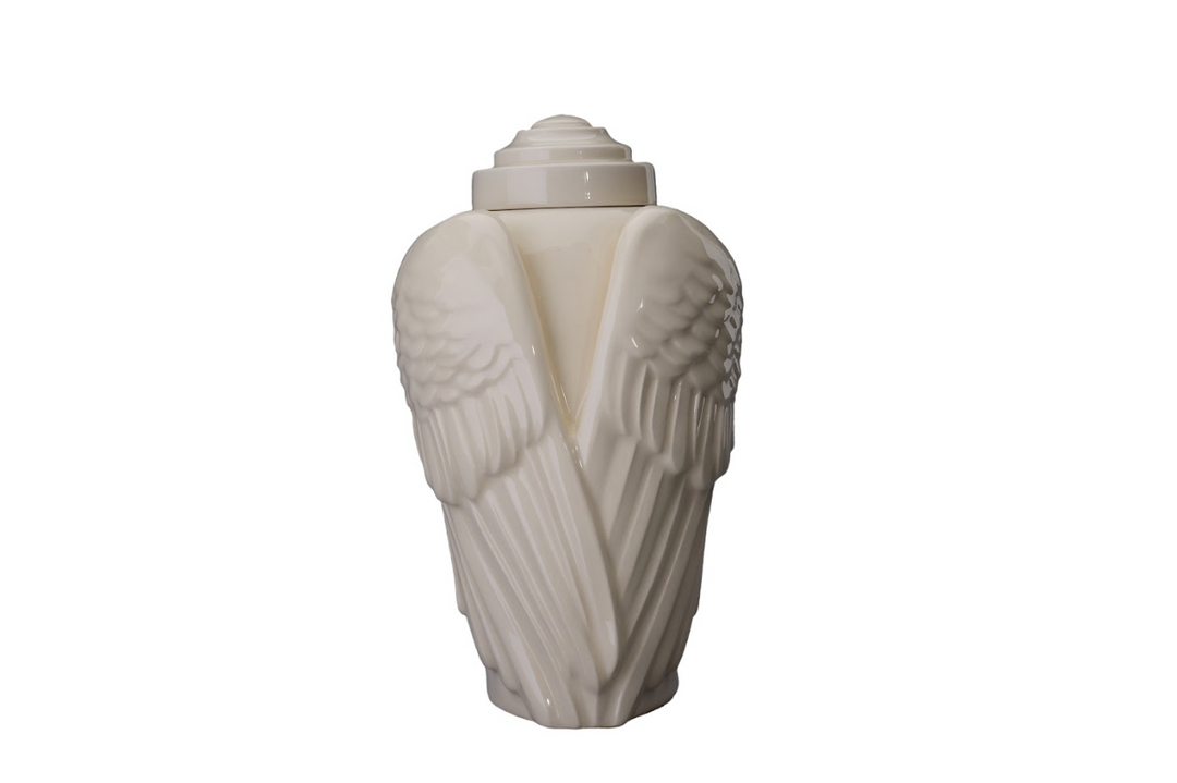 Beige Wings ceramic urn with carved wings and a separate wing keepsake beside it.