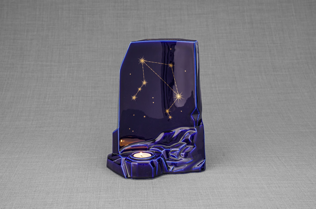 Zodiac Ceramic Urn in deep starry blue glaze with gold constellation pattern and a candle holder at the base