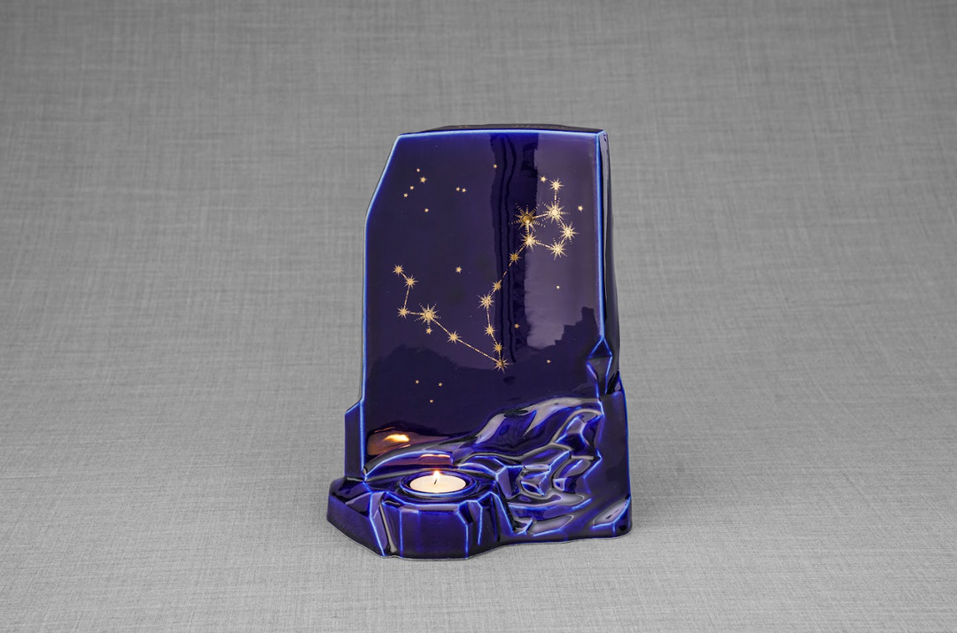 Zodiac Ceramic Urn in deep starry blue glaze featuring a different gold constellation design and a base for memorial candles