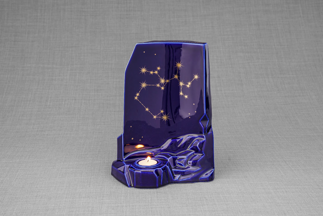 Zodiac Ceramic Urn in deep starry blue glaze with gold constellation motif and a candle space near the base