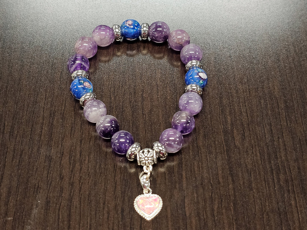 Purple amethyst and blue glass flower bead bracelet with a silver heart charm containing cremation ash.