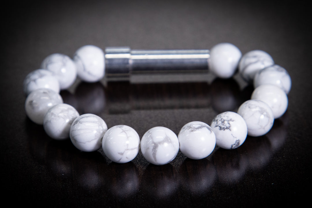 White howlite bead bracelet with gray marbling and a silver barrel clasp on a dark surface