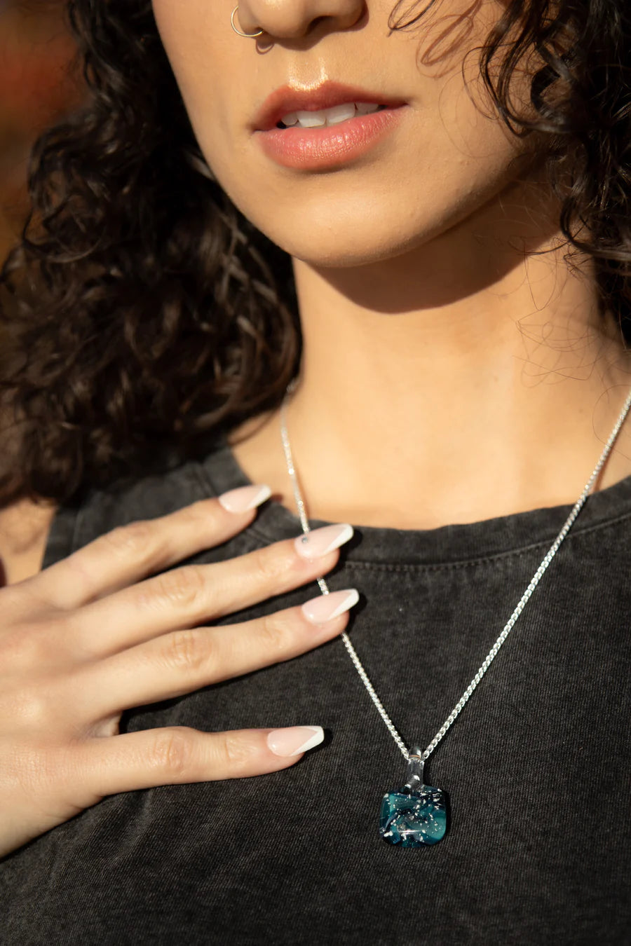Blue Spiral glass pendant infused with cremation ashes on a silver chain worn by a model