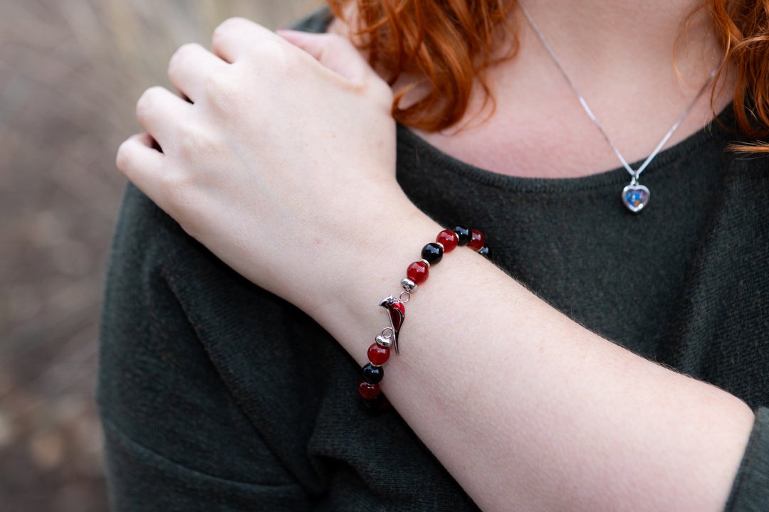 woman wearing cremation ash bracelet with cardinal charm