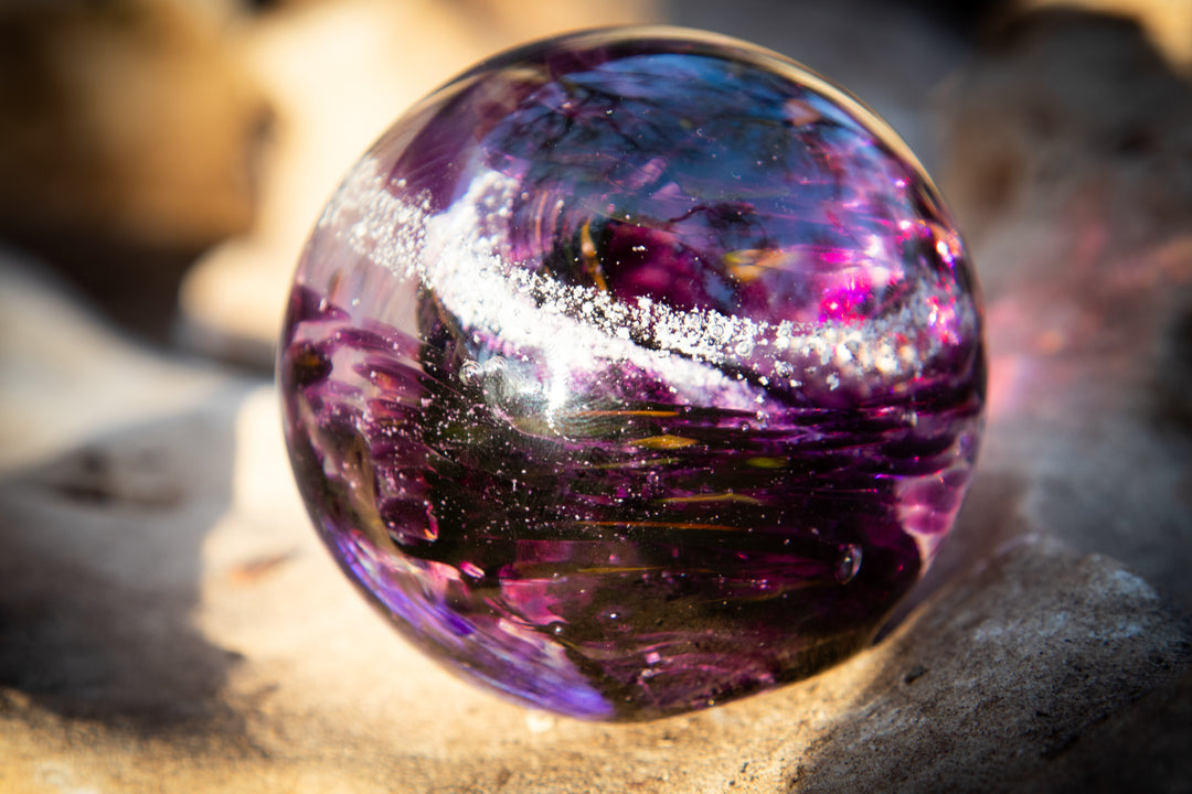 Vibrant purple cremation glass Serenity Orb with ashes swirled inside