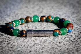 Multicolored beaded cremation bracelet with a silver clasp on a textured surface