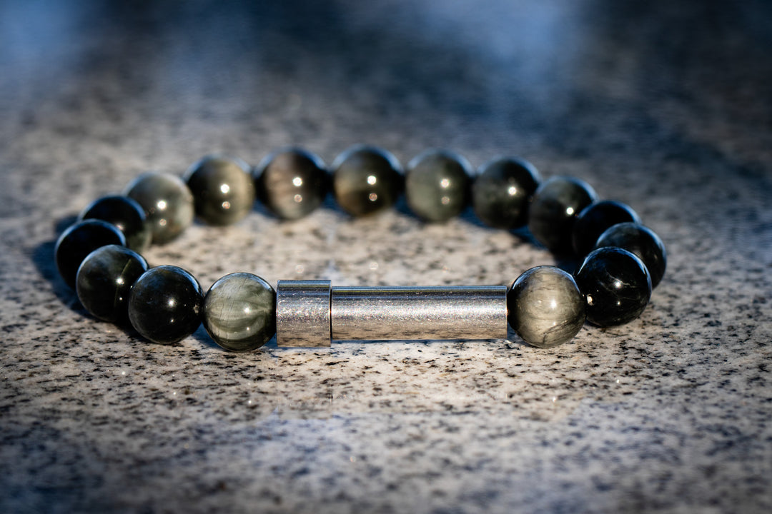 eagle eye memorial Beaded bracelet with a metal clasp on a textured surface