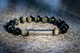eagle eye memorial Beaded bracelet with a metal clasp on a textured surface