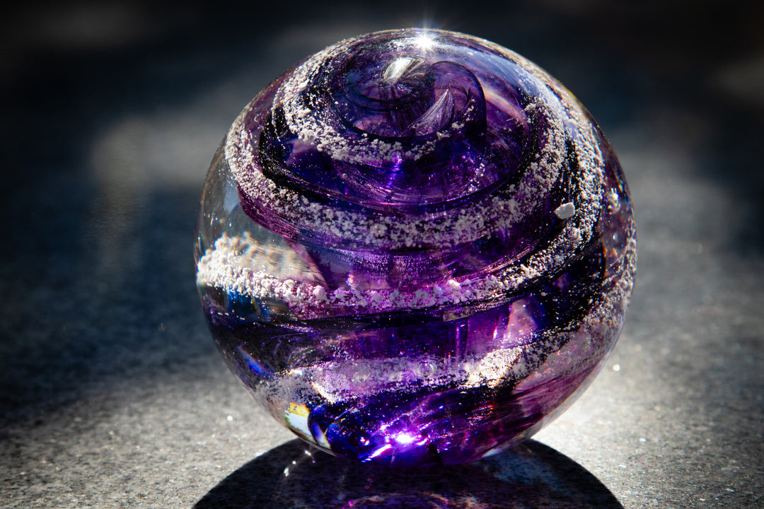 Purple Sparkle Orb with swirling violet ribbons and silver glitter on a dark surface.