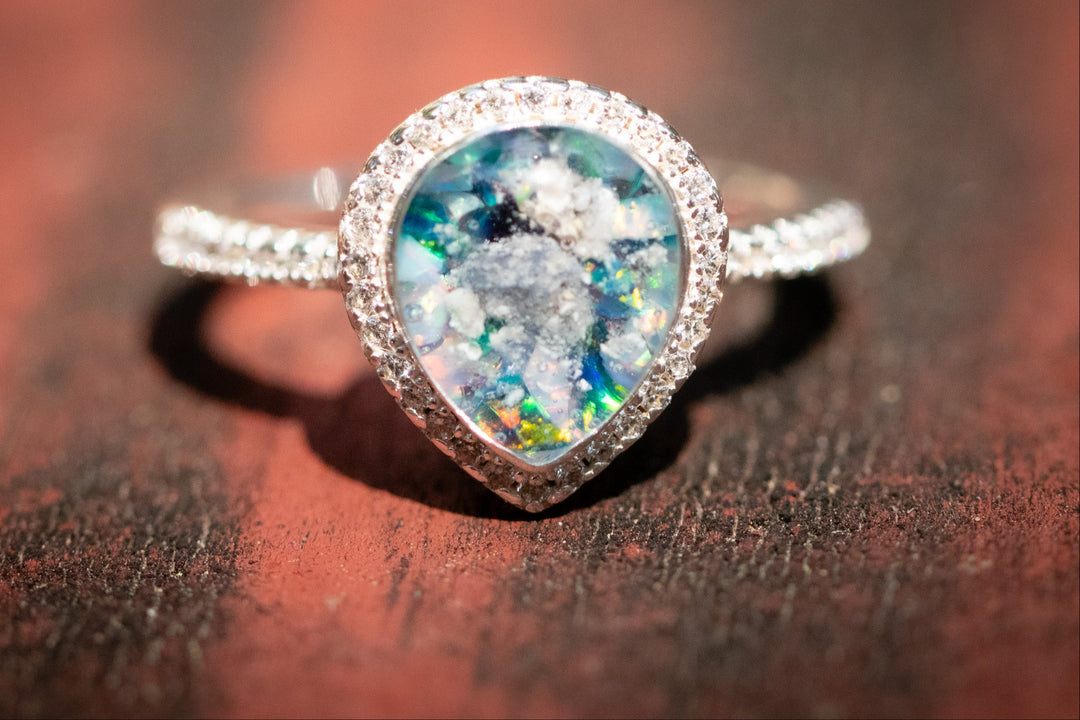 pear Ring with a colorful gemstone on a wooden surface. 