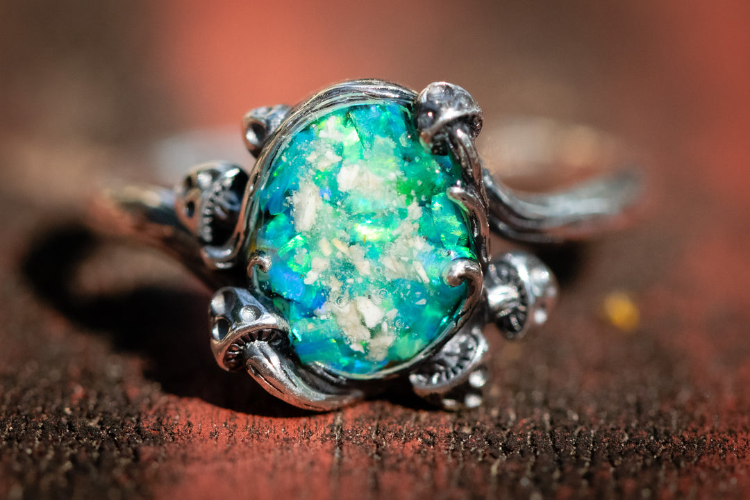 Ring with a green opal stone on a wooden surface. Turquoise and lime green