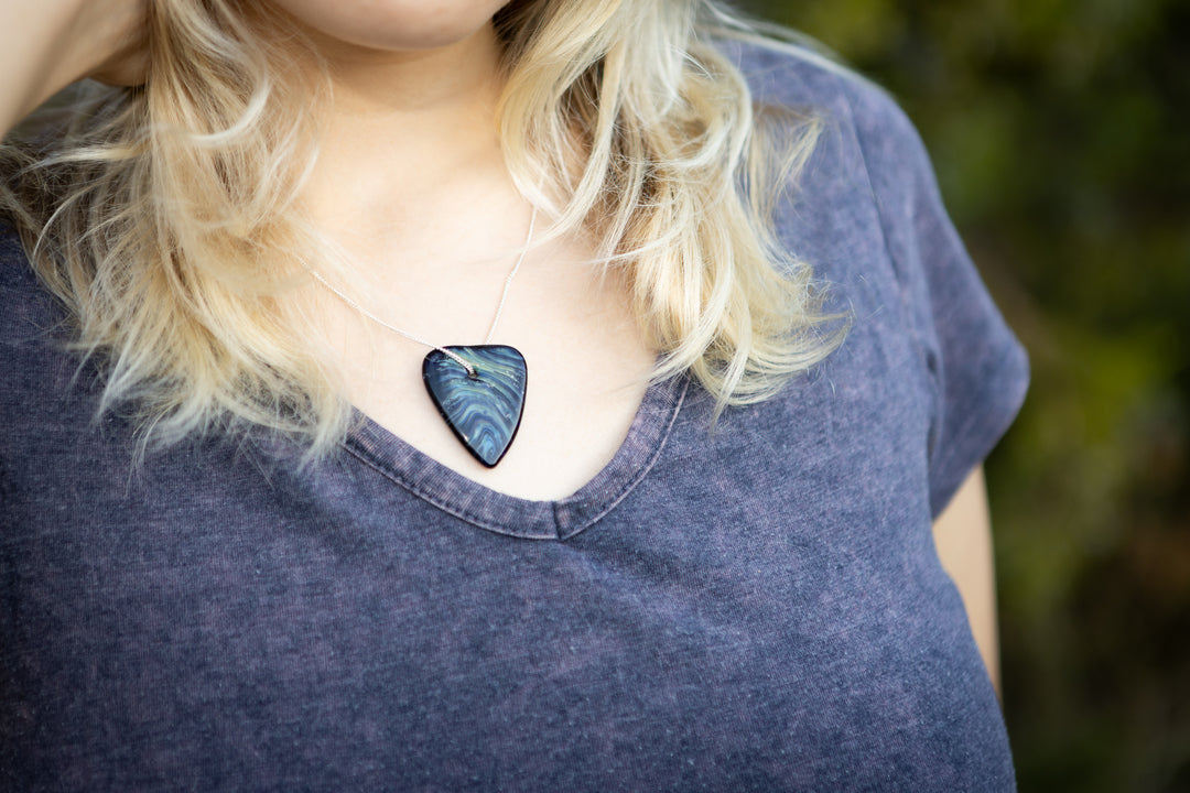 Colorful rainbow glass heart pendant on a silver chain worn by a person