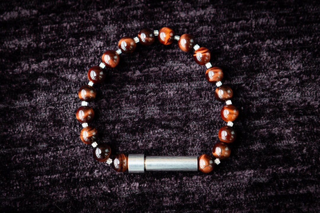 Bracelet with tiger eye beads and silver accents on a dark textured background