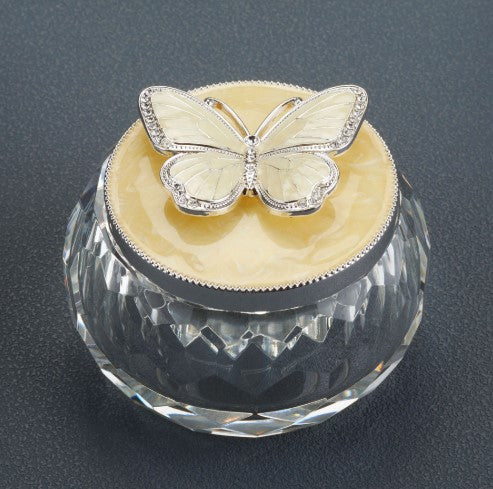Butterfly lid atop a faceted crystal urn base with a pale yellow interior.