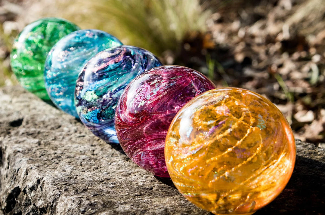 Colorful glass cremation marbles on a stone surface with a natural background
