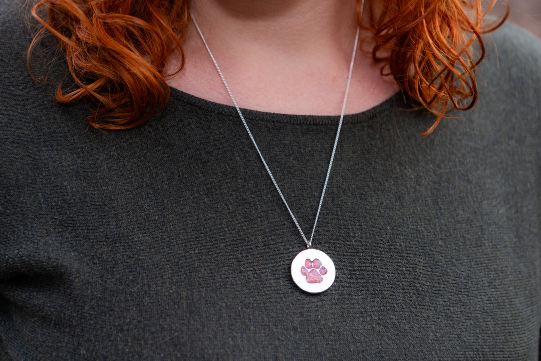 pawprint opal pendant with cremation ash being worn by woman