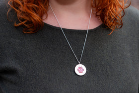 pawprint opal pendant with cremation ash being worn by woman
