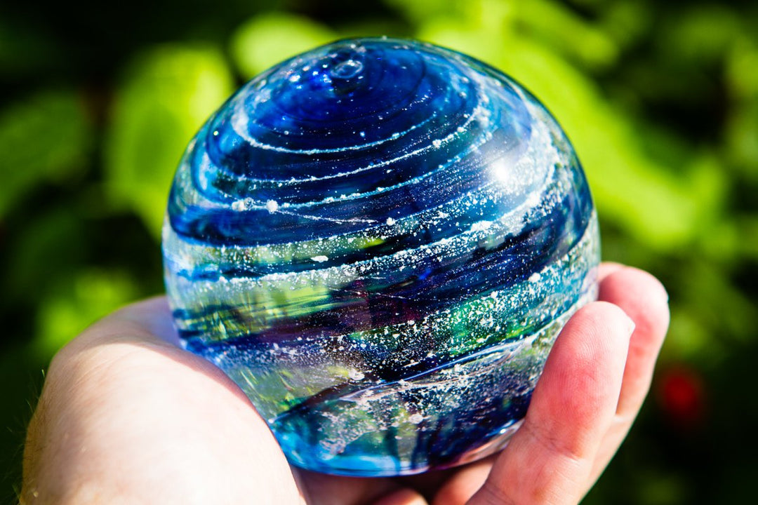 Blue glass Sparkle Orb with white speckles held in a hand