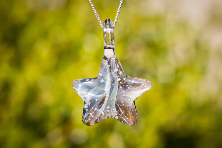 Star shaped glass pendant with wispy white swirls infused with cremation ashes on a silver chain