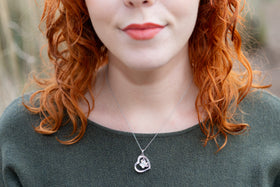 woman wearing pawprint cremation pendant
