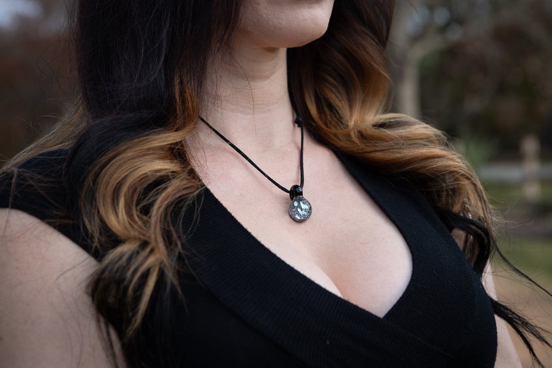 Howling wolf hologram pendant infused with cremation ash on a black cord necklace worn at the neck