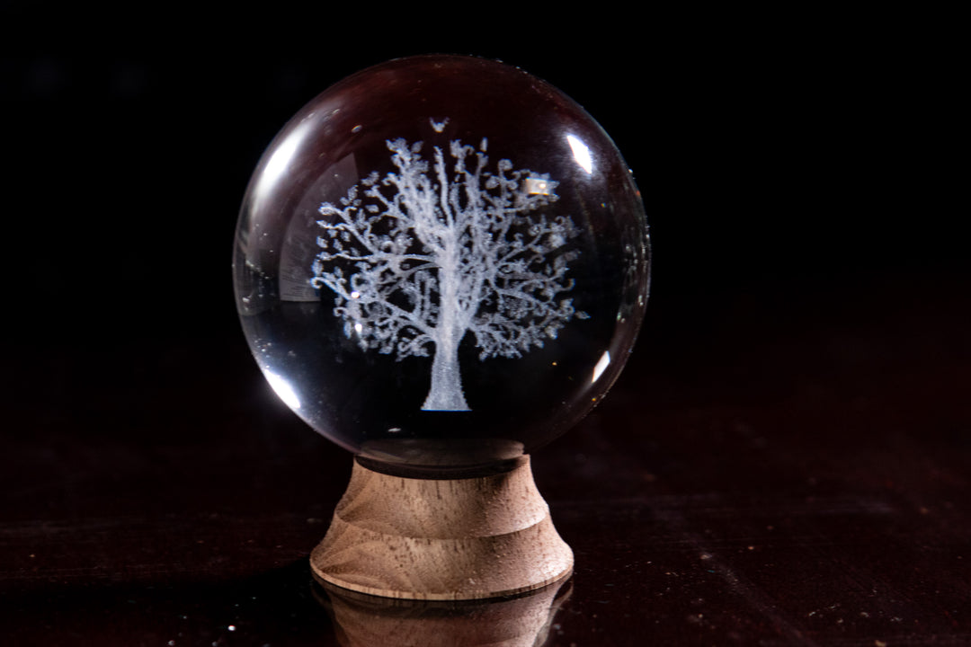 3D photo crystal marble urn with a white tree design inside the sphere on a wooden stand.