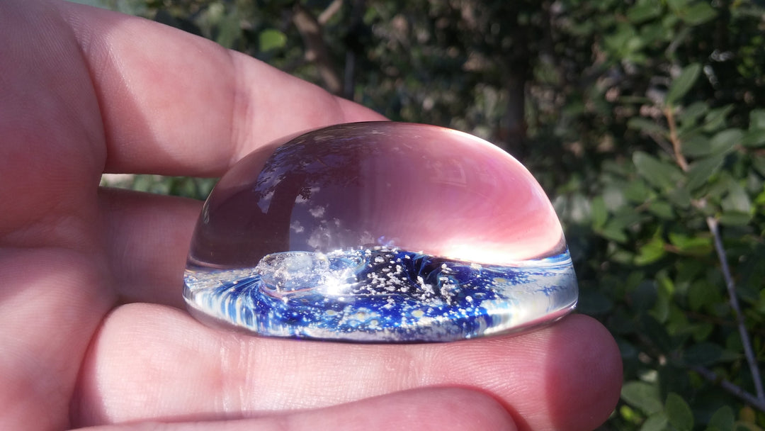 Purple Nightswirl glass paperweight showing a swirling space scene infused with cremation ash