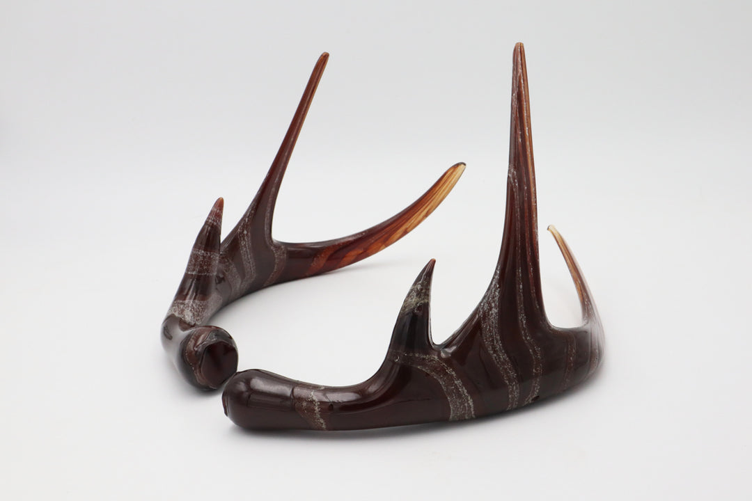 Brown resin deer antler sculpture with white marbling on a white background