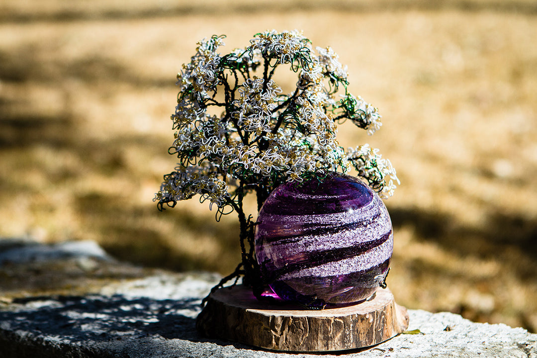 White Dogwood Tree of Life with Sparkle Swirl Orb shown in a collage of four outdoor angles on a wooden stand.