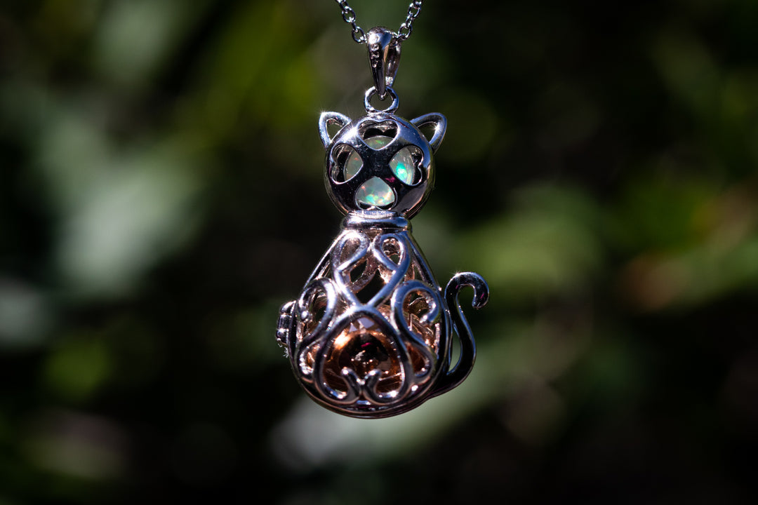 Opal cat urn pendant in polished silver with latticework and opal inlays on a delicate chain