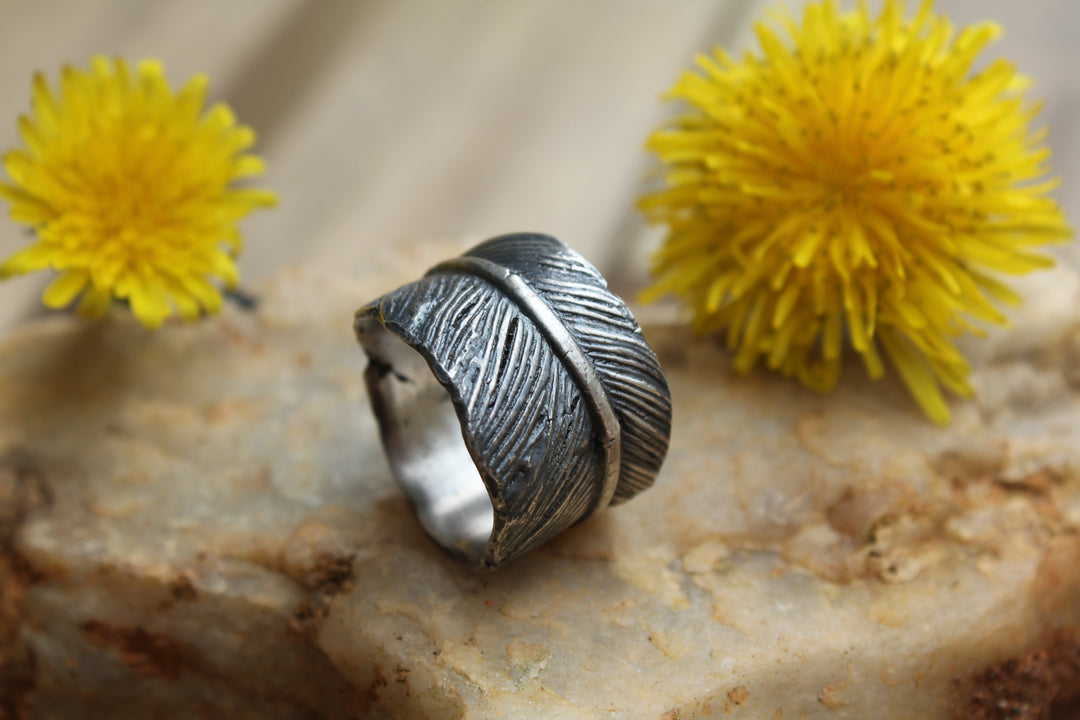 Silver Feather Ring infused with cremation ash with an antiqued finish and textured feather pattern.