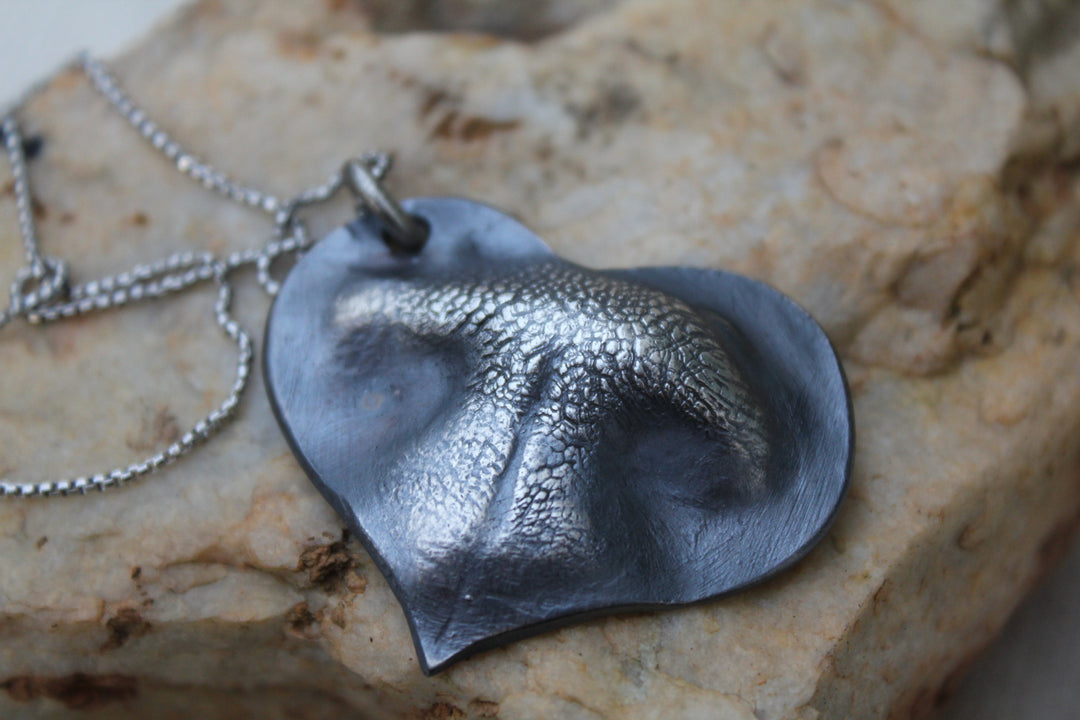 Sterling silver heart pendant with a textured nose print and paw print on a delicate chain