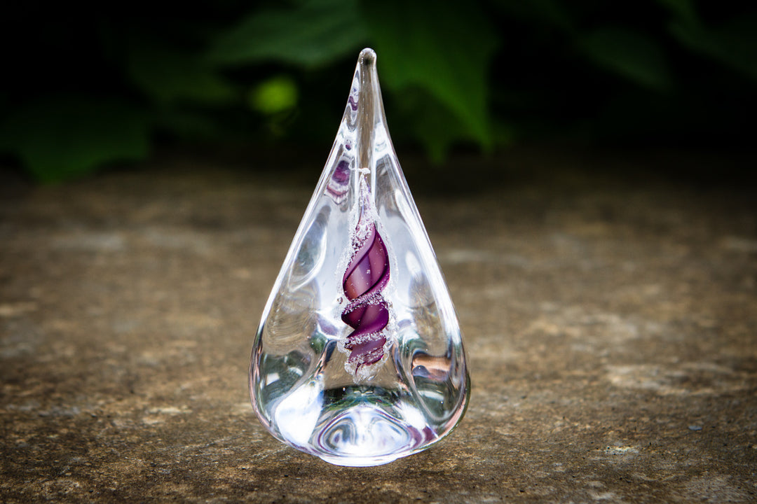 Clear teardrop glass memorial flame with purple cremation ash spiral inside