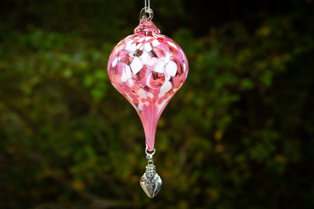 Pink mosaic glass teardrop ornament hanging from a ring with a silver ornate keepsake urn pendant