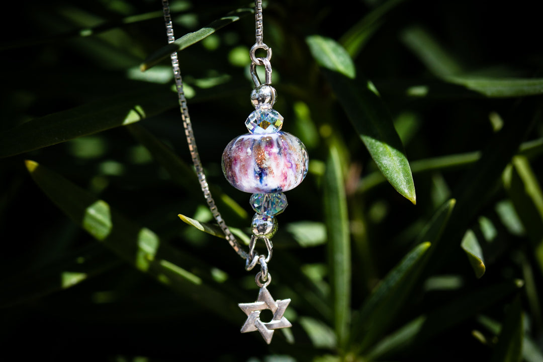Handmade glass bead bolo bracelet with cremains featuring a marbled purple bead and crystal spacer
