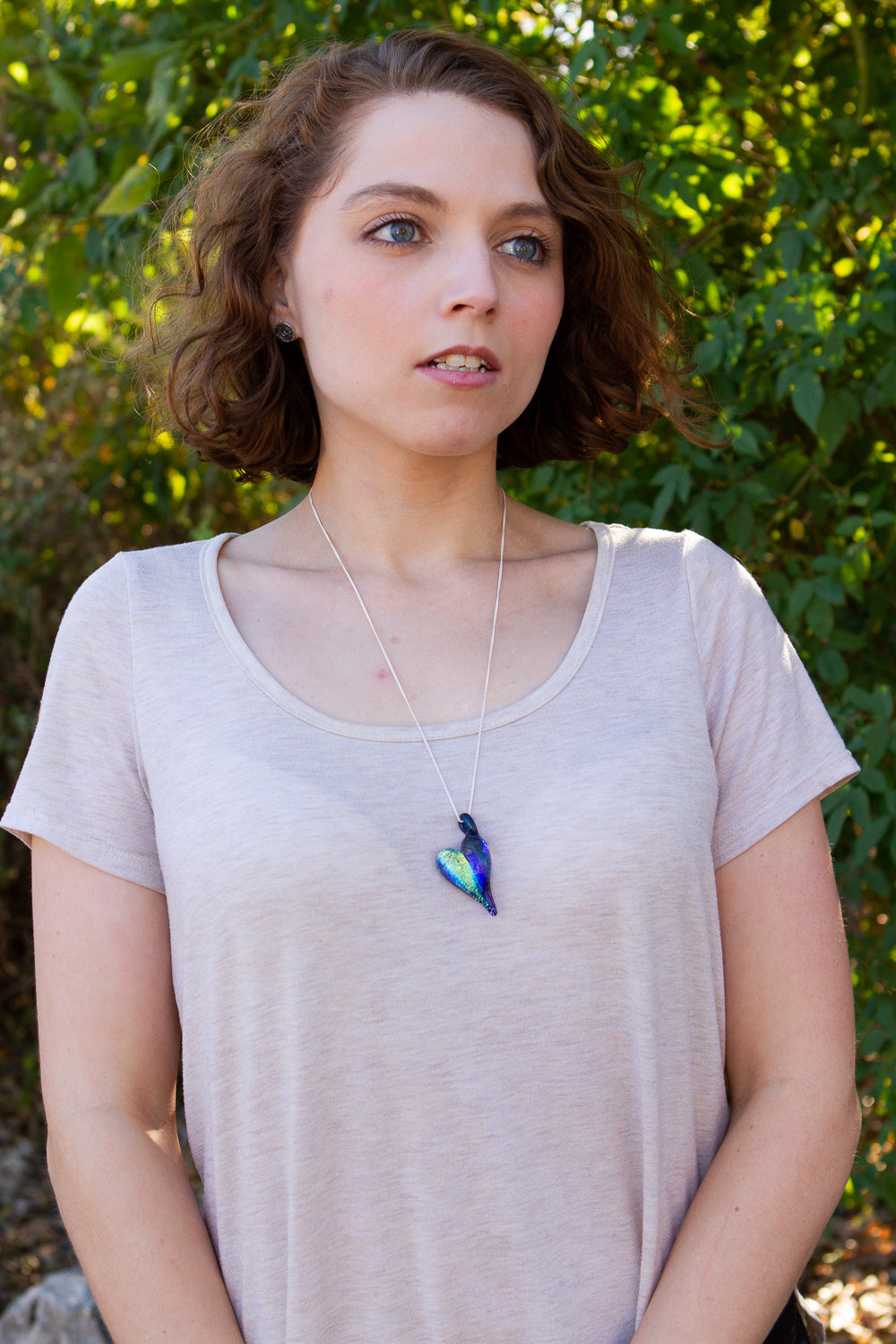 Iridescent dichroic glass heart pendant on a silver chain with cremation ashes