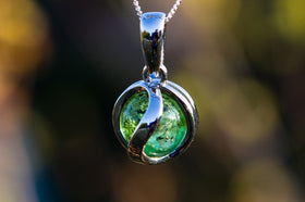 Sterling silver pendant holding a rotating green ash infused 10mm marble.