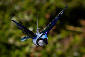 glass bluejay figurine with ashes