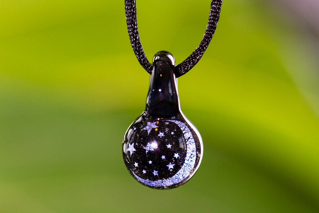 Glass Moon and Stars hologram pendant infused with cremation ash featuring starry design hanging from a cord