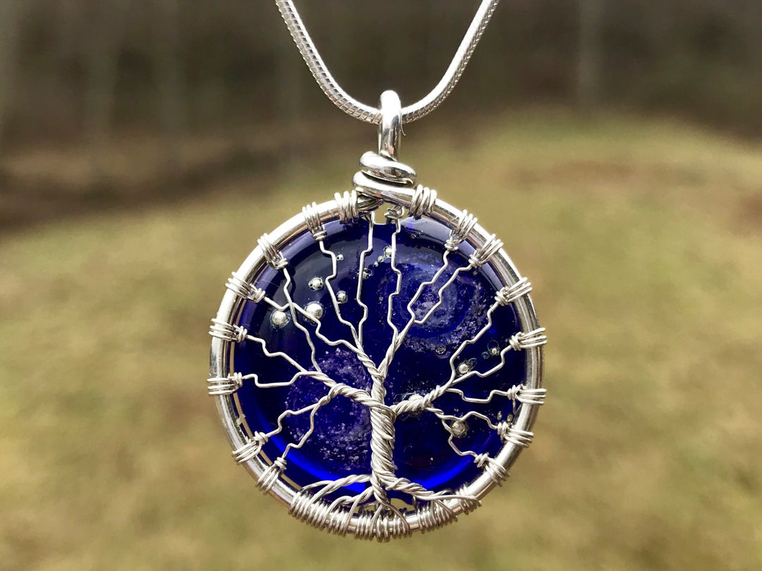 Cobalt Starry Galaxy Tree of Life pendant with a silver wire tree wrapped around a deep blue glass bead; cremains visible on the back.